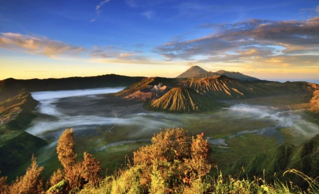 Tengger Caldera view during the sunrise golden hour. In the front is Mount Batok, Bromo Crater is right behind it, and in the far back is Mount Semeru, the highest mountain in Java.