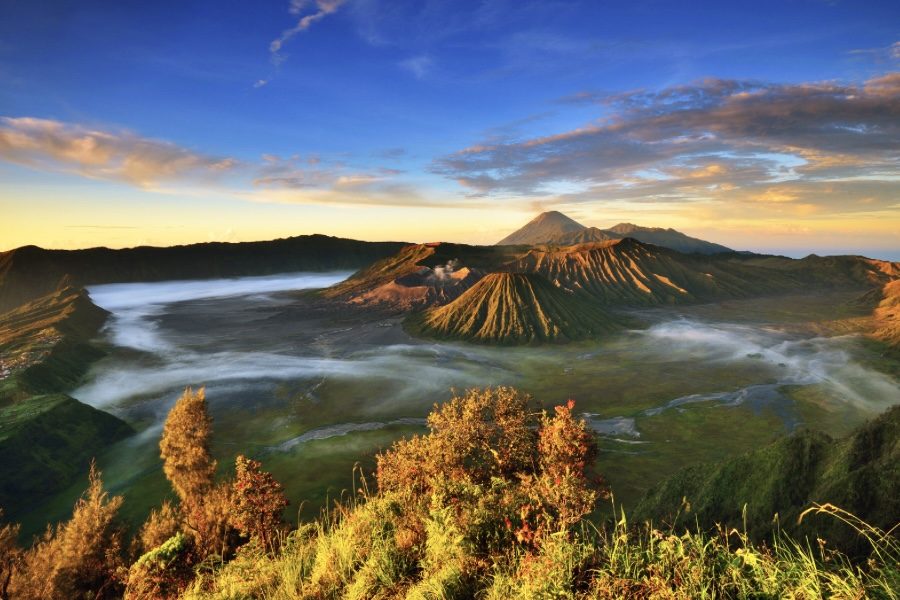 Tengger Caldera view during the sunrise golden hour. In the front is Mount Batok, Bromo Crater is right behind it, and in the far back is Mount Semeru, the highest mountain in Java.